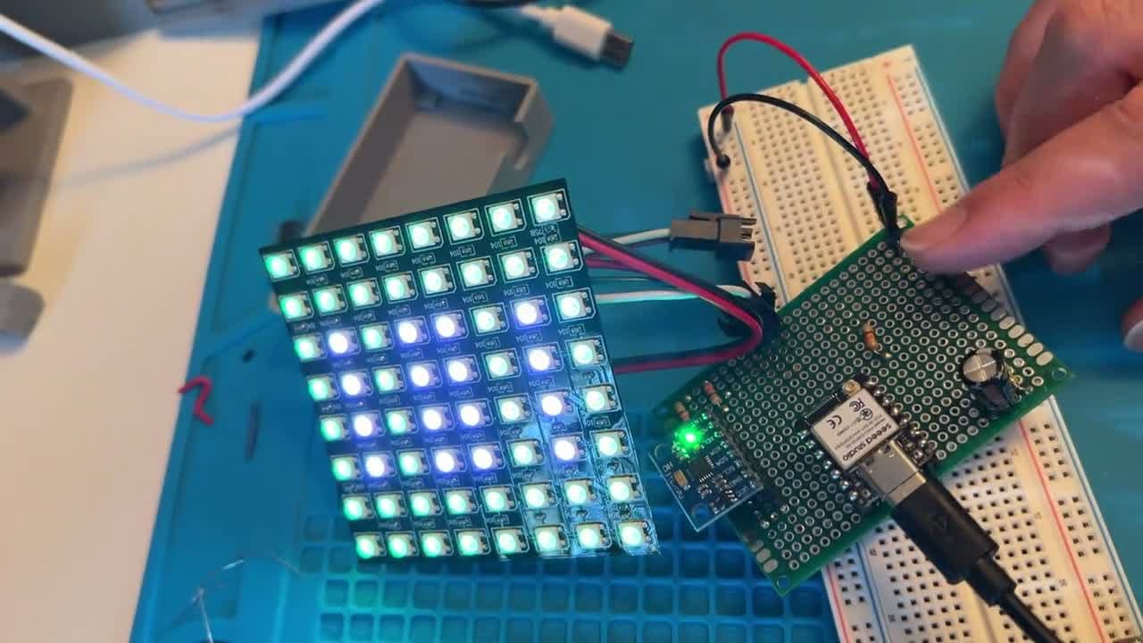 The LED matrix panel powering on, lighting from dark to a grid of white and colored pixels.